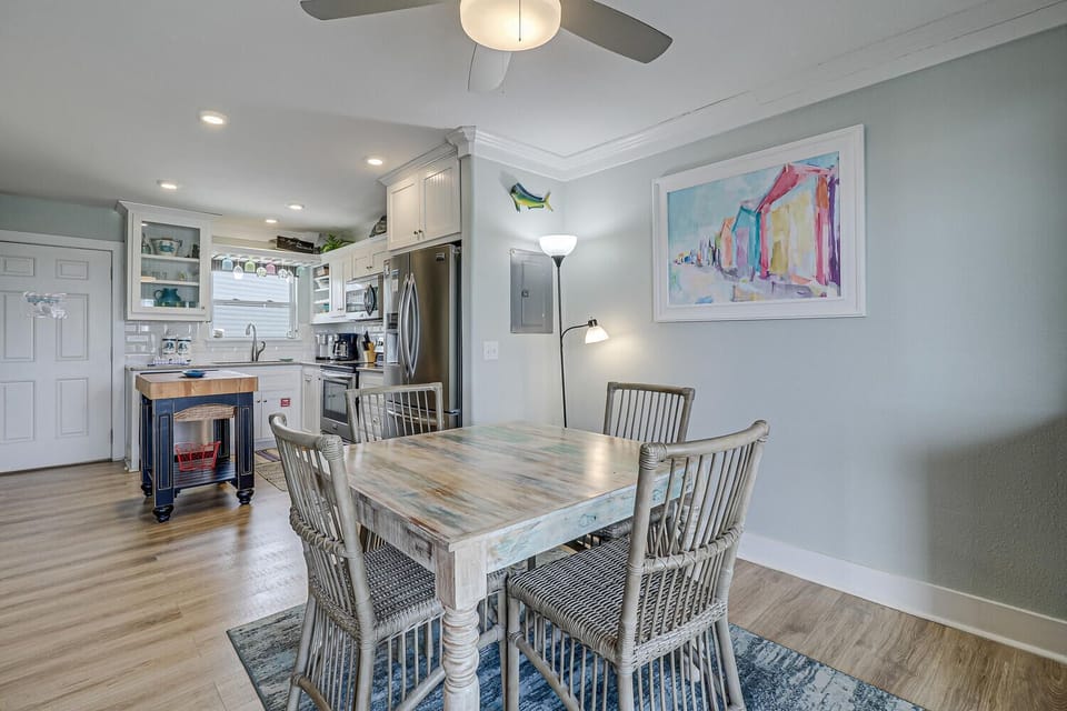 Your open-concept kitchen and dining area features coastal charm with weathered wood furnishings, modern appliances, and soothing sea-glass colors.