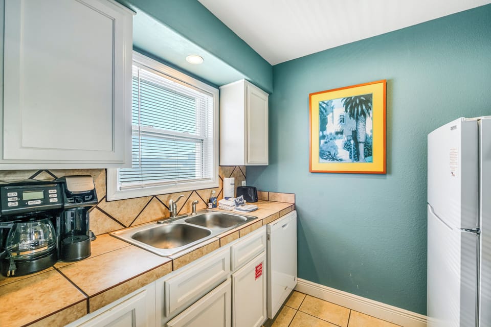 Your fully equipped kitchen awaits with everything needed to prepare meals, from morning coffee to family dinners in this charming coastal-themed space.