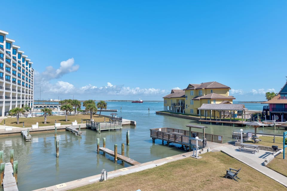 Waterfront location featuring marina, hotel building, and colorful overwater structures with fishing docks and boats nearby.