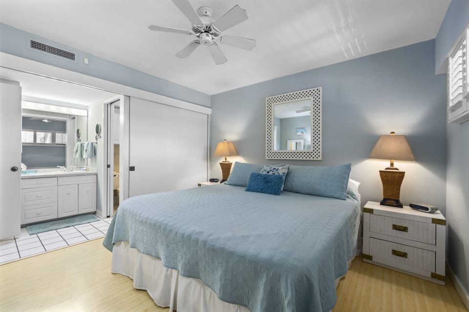 Drift off in this calming coastal bedroom where soft blue tones and natural textures invite your most restful sleep, cooled by ceiling fan and AC.
