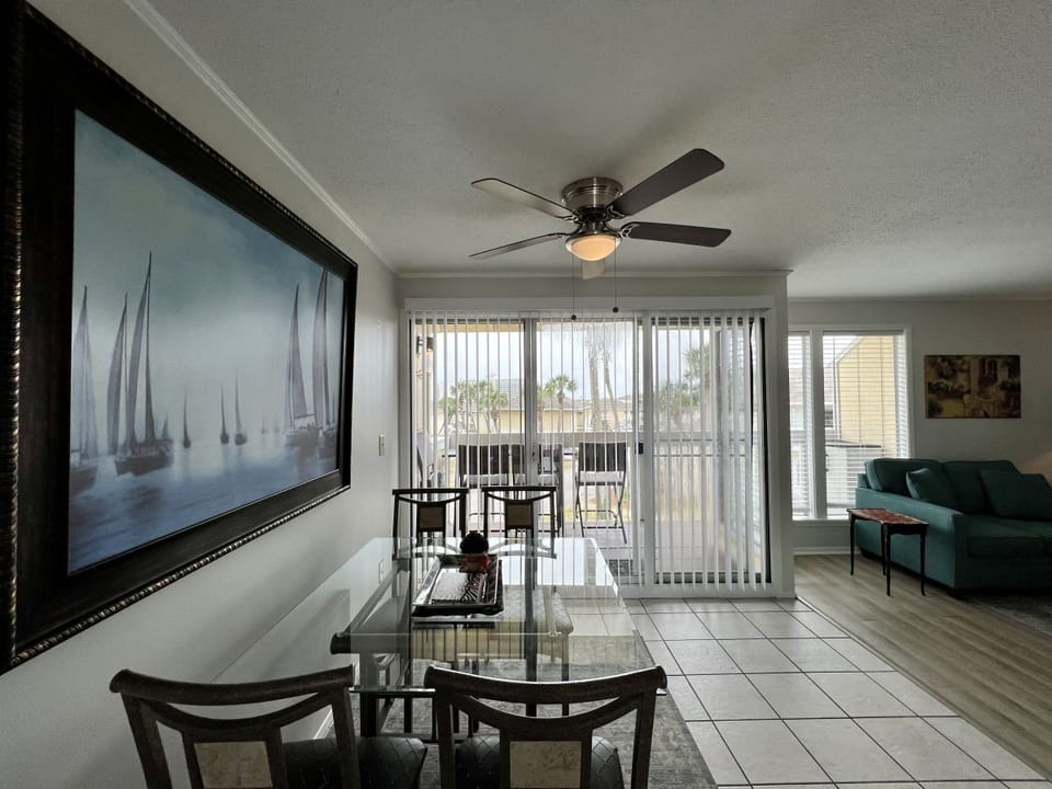 Relax in your bright dining space with glass table and nautical artwork, steps from your private balcony.