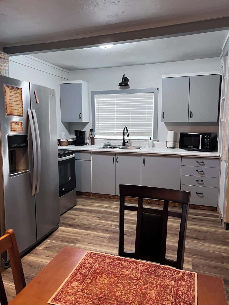 Bright full kitchen with stainless appliances, modern cabinets, coffee maker & dining space. Perfect for game day meals before heading to Autzen Stadium or relaxing dinners in the Springfield historic district cabin.