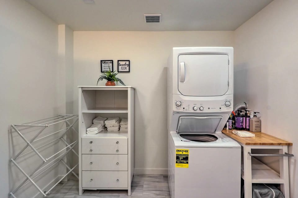 The hallway bathroom complete with a washer/dryer, laundry detergent and towels.