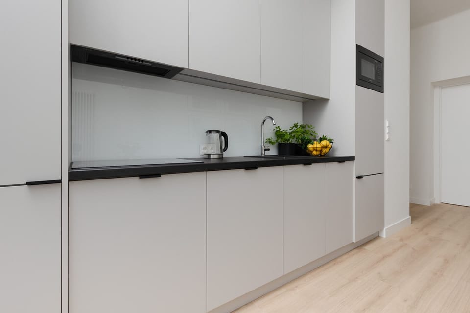A sleek and modern kitchen with white cabinetry and a clean design.
