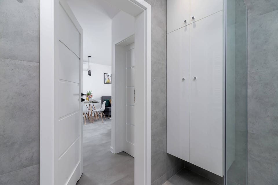 A hallway leading to various rooms, showcasing a clean and modern aesthetic.
