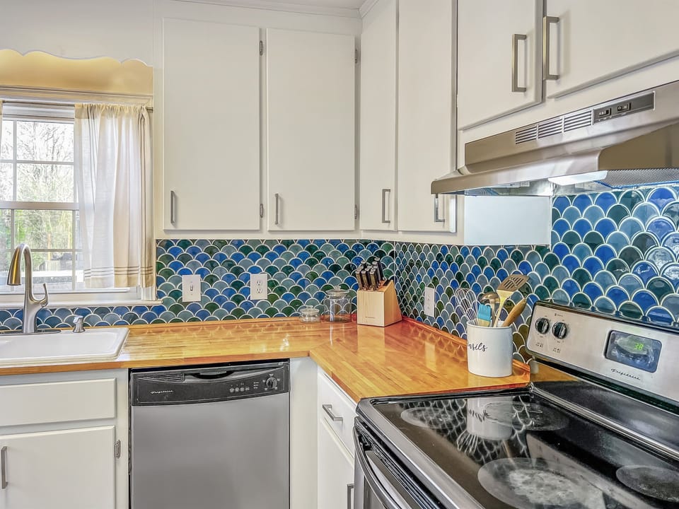 Who doesn't love a brightly lit, clean kitchen? The gorgeous butcher block and decorative tile freshen up the space and give this a kitchen a modern, relaxed feel.
