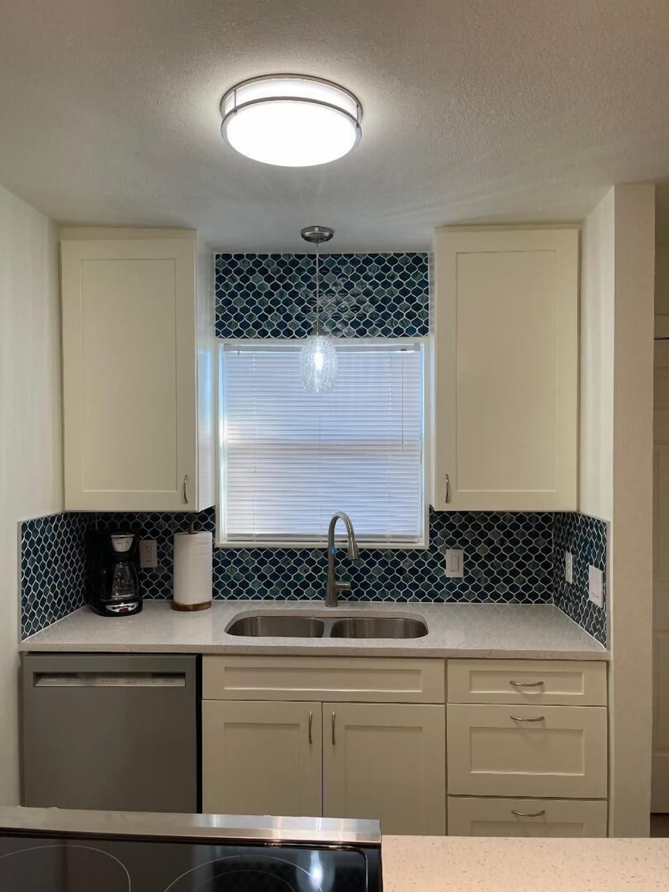 Your bright kitchen features modern appliances and elegant blue mosaic backsplash, creating a stylish space for preparing meals during your stay.