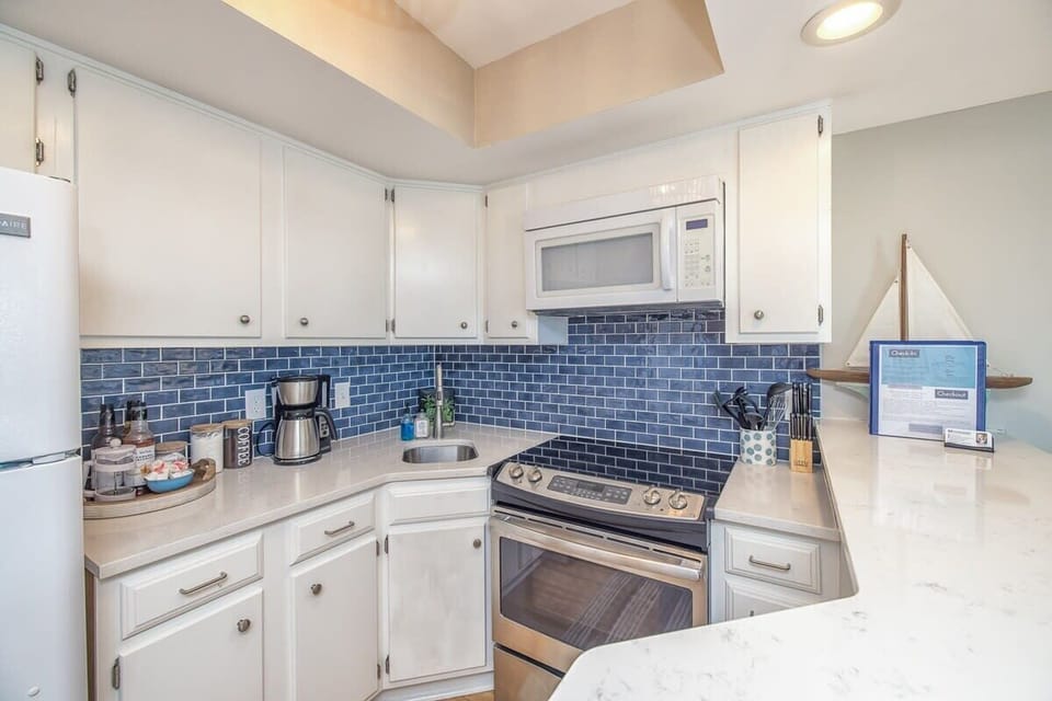The updated kitchen is tiny but mighty! Full size appliances and fully stocked.