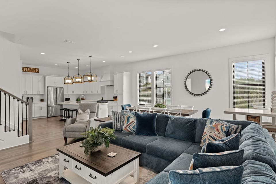 2nd Floor - Your spacious open-concept living area flows seamlessly from plush seating to a modern kitchen, with warm wood floors, abundant natural light, and a welcoming dining area—perfect for gathering and unwinding.