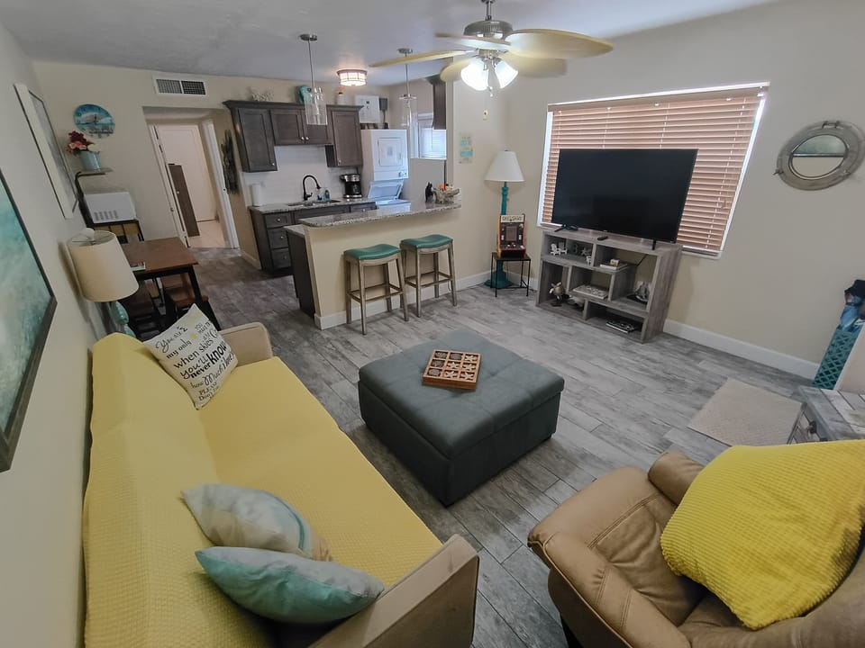 Plenty of room, seating, fold down futon couch, open kitchen design, and Roku TV