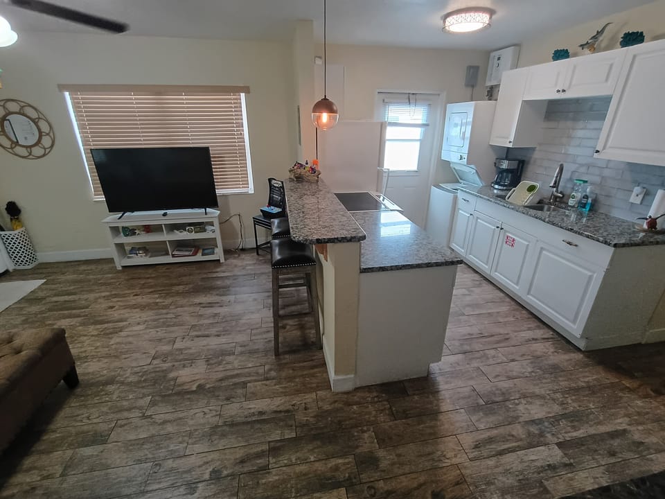 Open kitchen to cook and enjoy conversation with breakfast bar and living room.