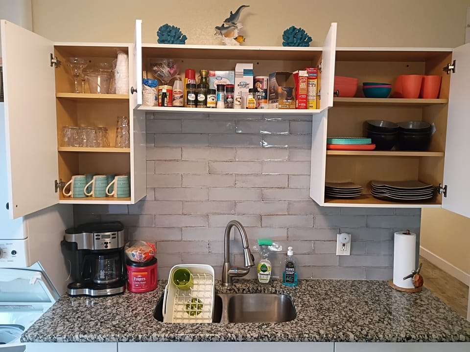 Cabinets have dishes, cups, plastic, spices, coffee, and lots of extras.