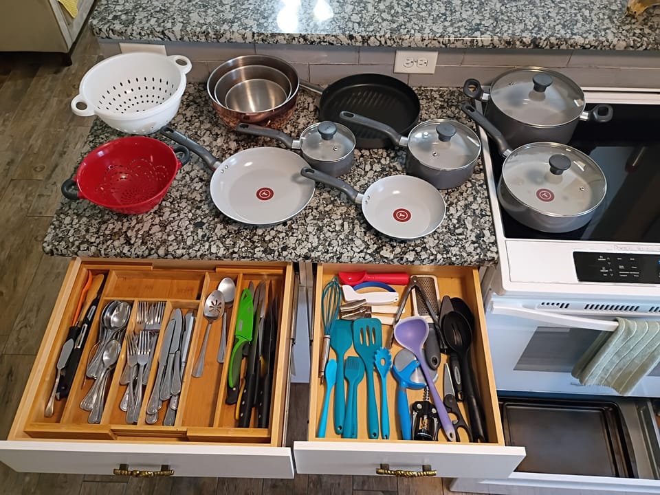 Glass-top stove, nonstick pots/pans, silicone utensils, mixing bowls, silver.
