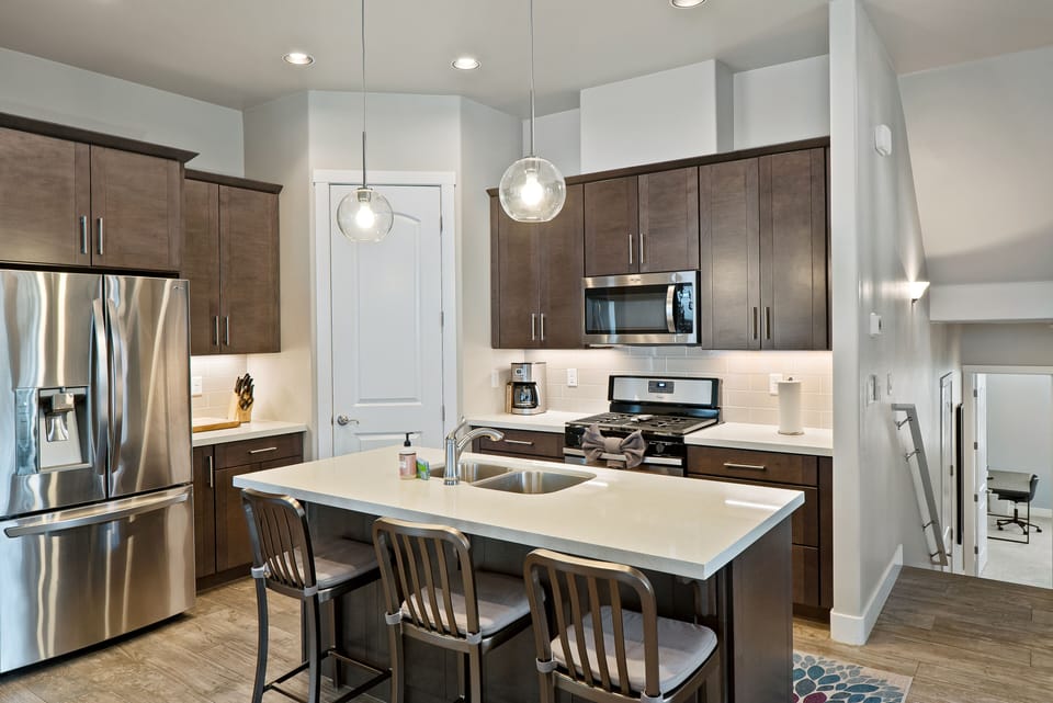 Fully Equipped Kitchen: Cookware, stainless steel appliances, and a cozy dining area for shared meals.