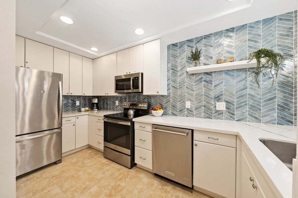 Modern kitchen with stainless steel appliances, granite countertops, and ample storage.