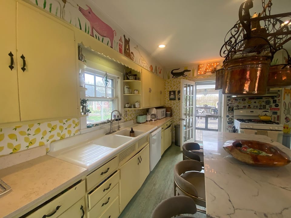 double sink, stove, seating by island, hand painted farm scene on wall border