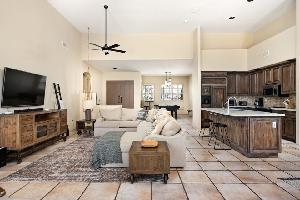 Bartop seating at the kitchen island. A large sectional is in the living room.