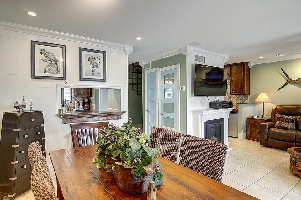 Your open-plan living space blends coastal charm with comfort, featuring elegant furnishings and a cozy fireplace for memorable evenings together.
