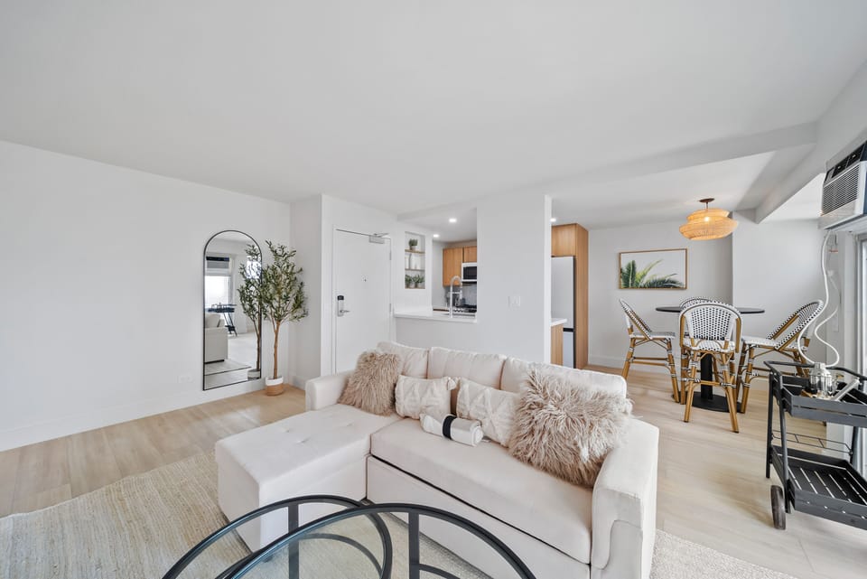 Living room with TV and sofa bed - Gather in an open-concept space designed for connection, with cozy seating and a seamless flow into the dining area—ideal for unwinding after a day at Waikiki Beach.