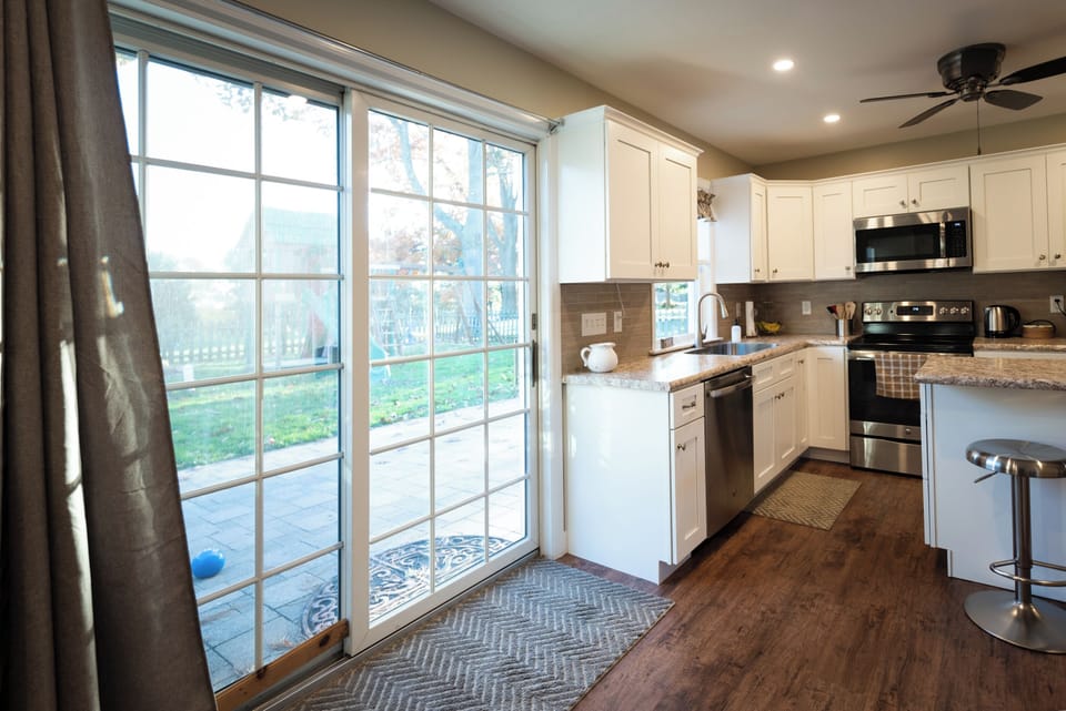 A sliding door provides access to the patio, play yard and fire pit area.
