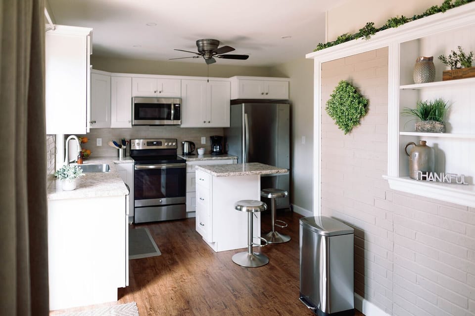 The kitchen features full size appliances and a island with seating for two.