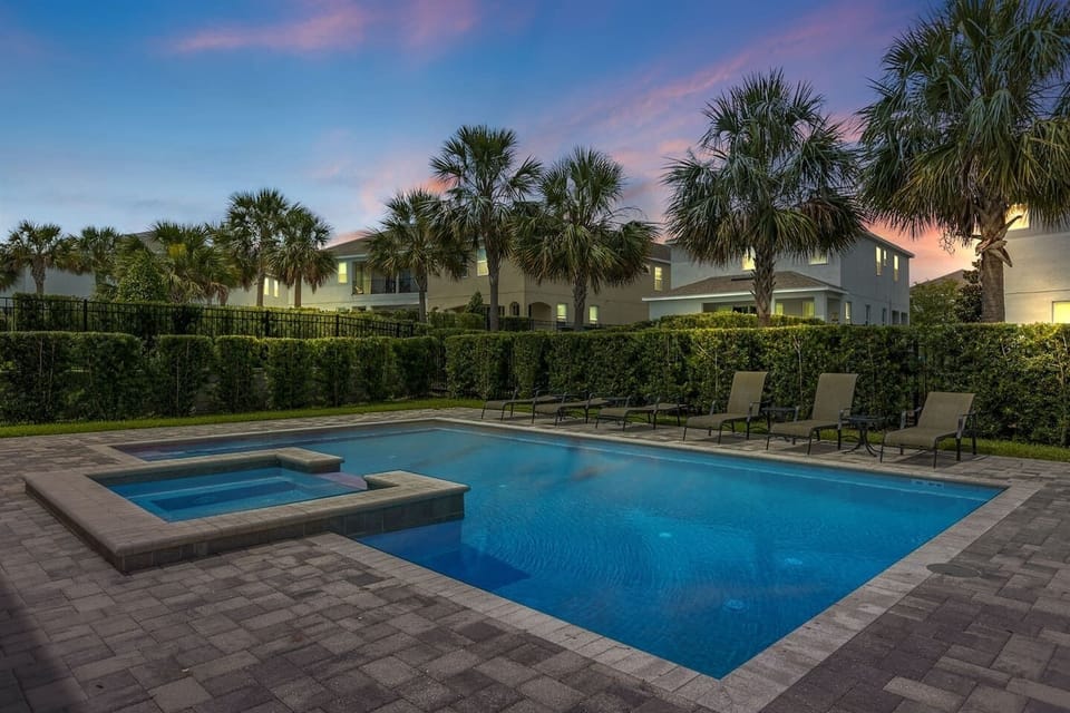 Experience evening tranquility by the poolside, where sunbathing chairs await amidst lush greenery. The warm glow of sunset casts a magical ambiance, complemented by soft lighting, creating a perfect setting for relaxation and memorable moments.
