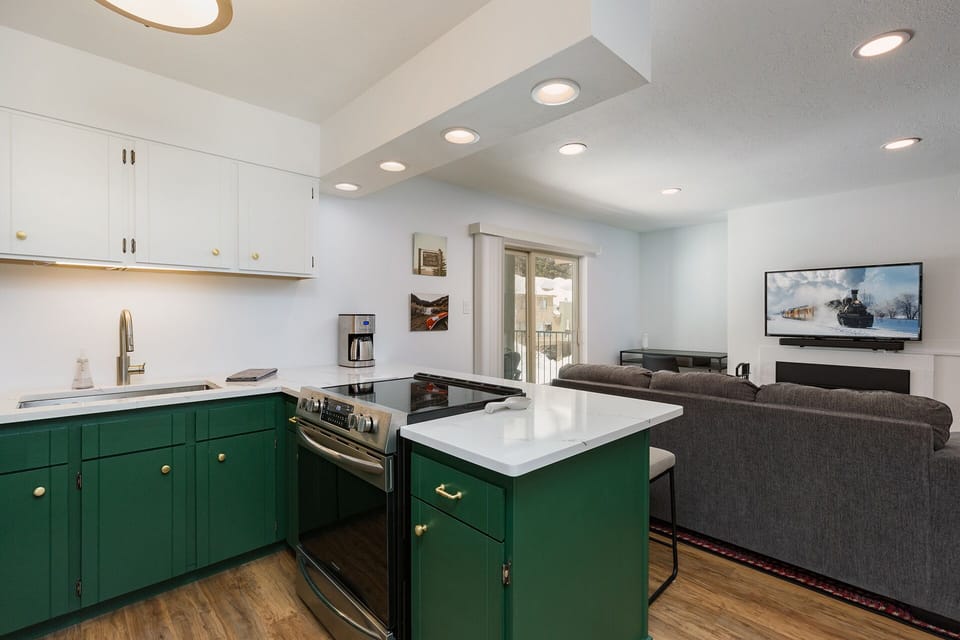 Updated, Fully Stocked Kitchen with Breakfast Bar and Seating - View of the Living Room and TV
