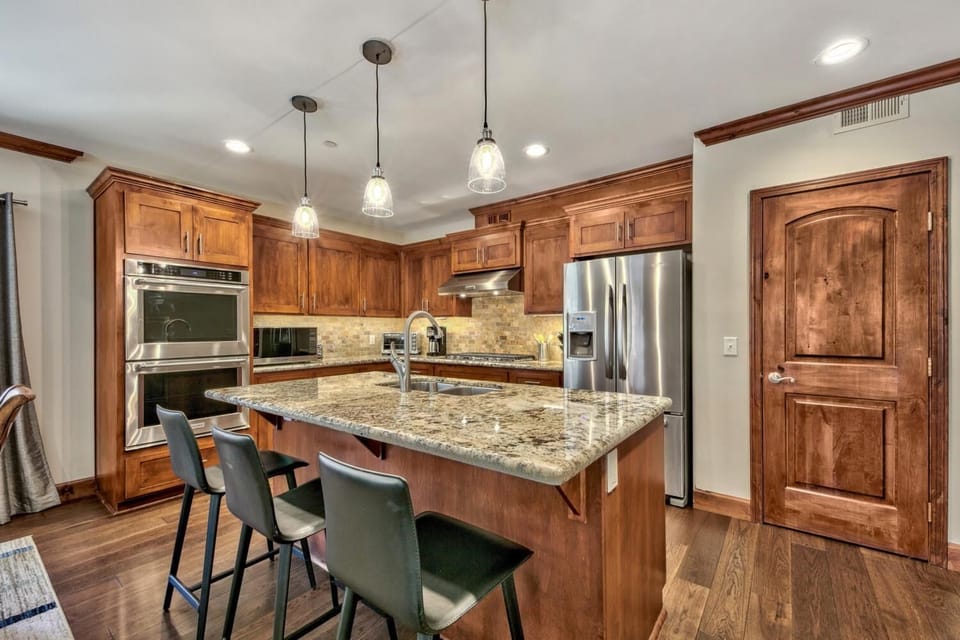 You'll love cooking in this elegant gourmet kitchen with granite countertops, warm wood cabinetry, and modern stainless appliances.