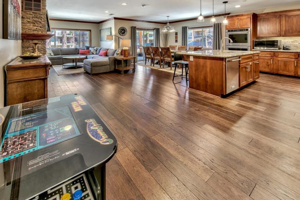 Spacious open-plan living where you'll cook, dine, and unwind together. Rich wood floors and stone fireplace create warmth for memorable evenings.