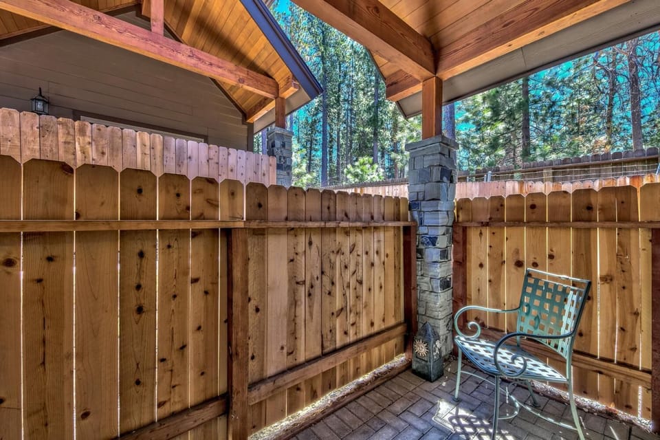 Your private covered patio offers a peaceful retreat with forest views, where you can relax in comfortable seating surrounded by natural wood details.