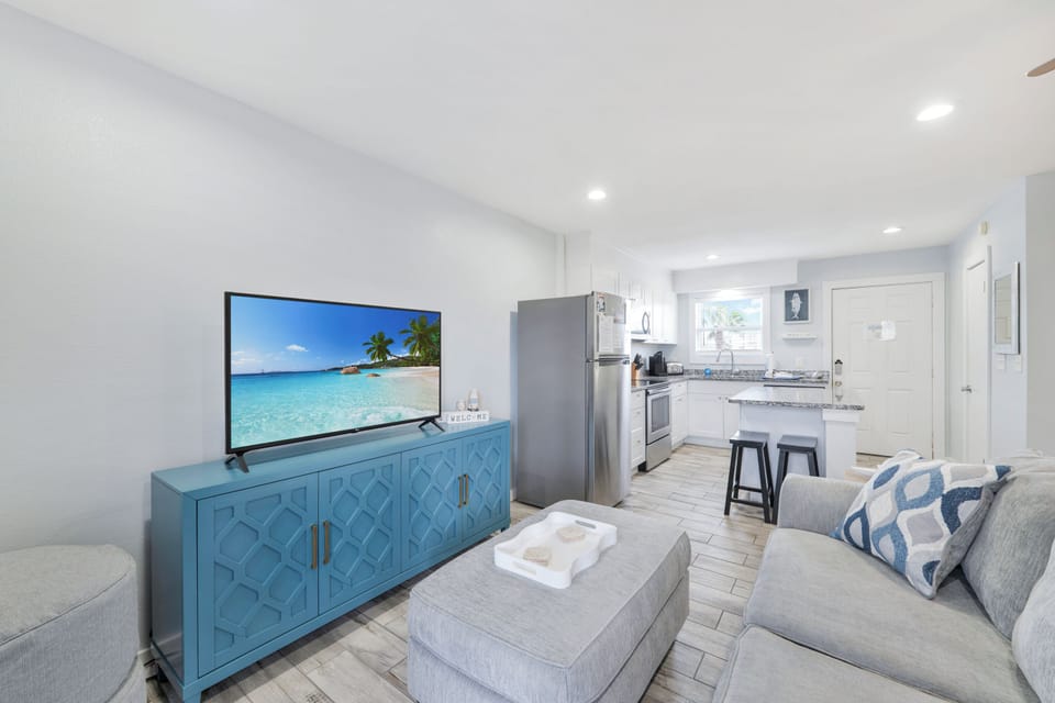 Relax in your bright, open living space where coastal charm meets modern comfort with stylish blue accents and a fully equipped kitchen.