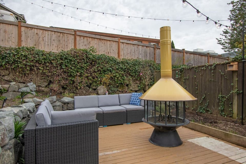 The beautifully landscaped backyard has plenty of outdoor patio furniture as well as a vintage fire pit.
