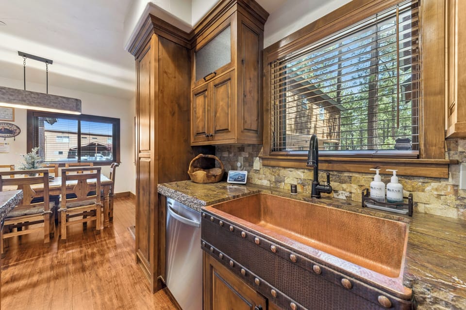 Step into your rustic-elegant kitchen featuring rich wood cabinetry and a stunning copper farmhouse sink that adds warmth to every meal prep.