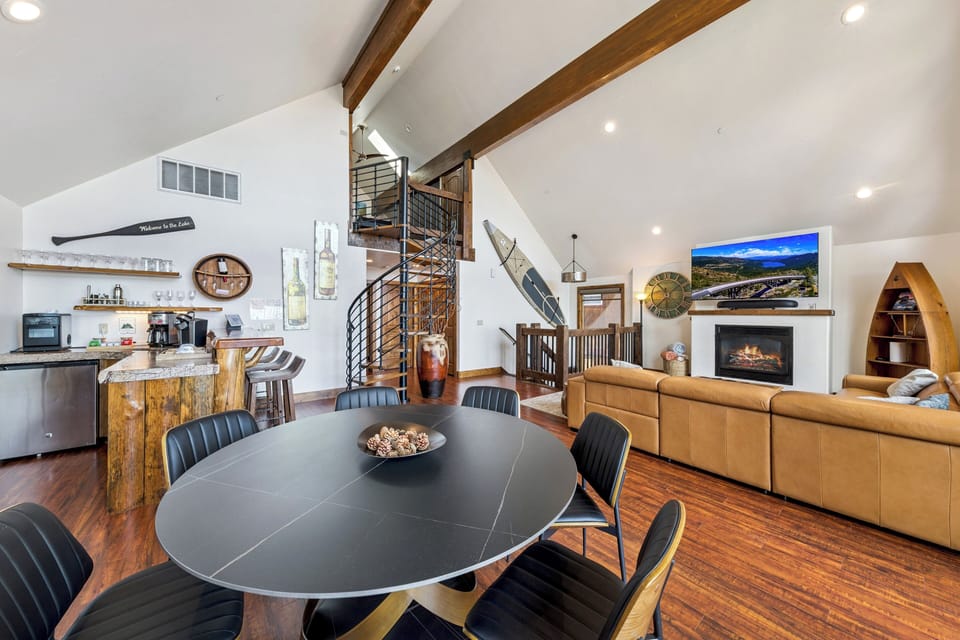 Open-concept second floor with dining area, great room, wet bar, spiral staircase, and warm mountain-lodge design