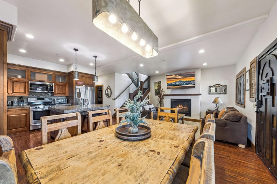 First-floor dining area with a large wood table, open seating, and direct connection to the kitchen and living room
