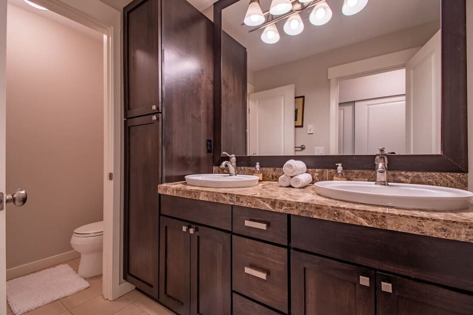 Another angle of the bathroom with sinks and toilet.