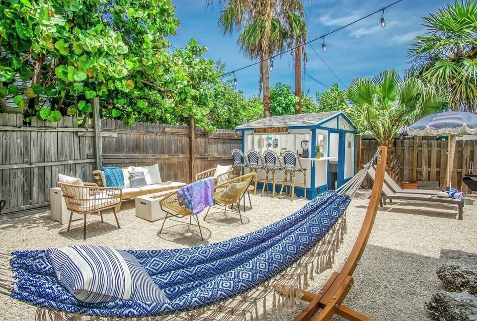 There are so many hangout areas in your private fully fenced backyard! Hammock, firepit, sofas, loungers, Propane Grill and custom TIki bar table, Beach games, Custom TIki Bar and backed stools, bistro set, the list goes on!