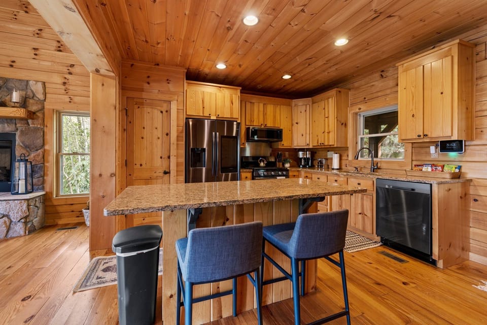 A fully stocked kitchen and island offer seating for two. 
