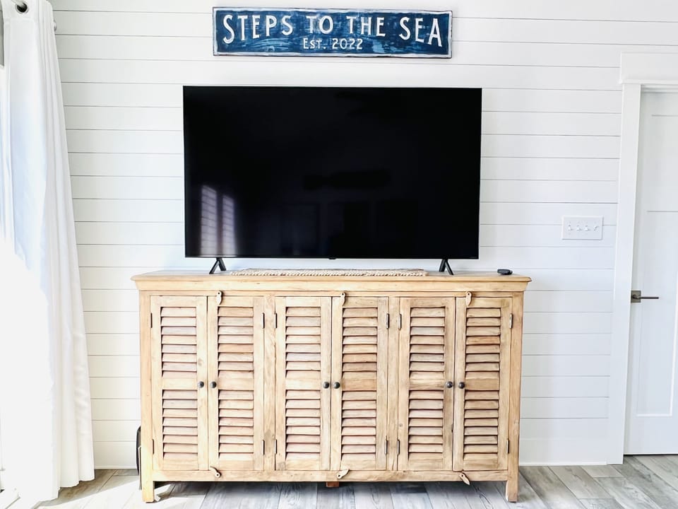 Living area 65" smart TV with Hulu Live, Netflix & Disney+. 