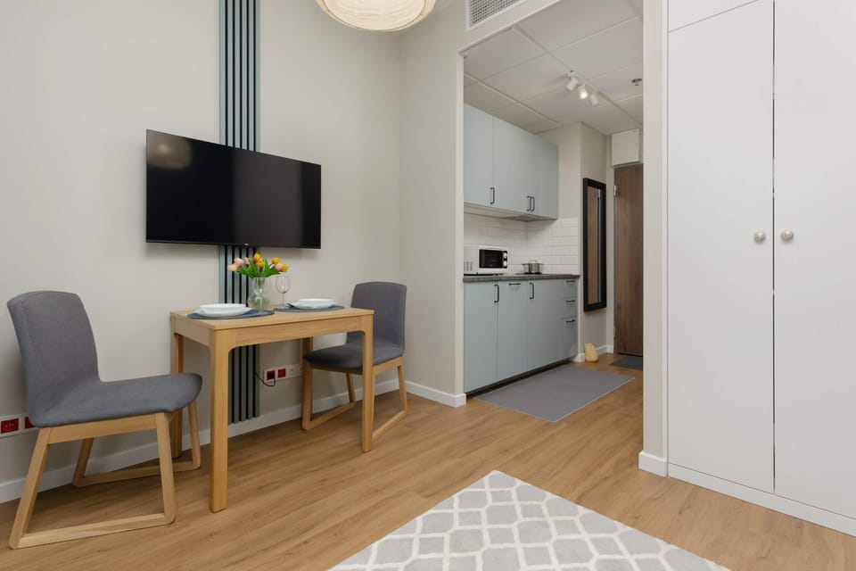A small dining table set with dishes, placed near a window for a bright and pleasant dining experience.