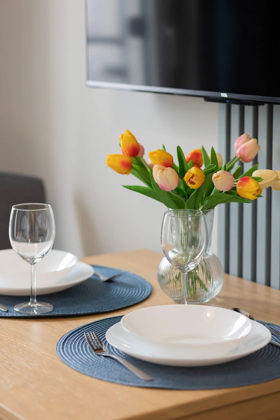 A small dining table set with dishes, placed near a window for a bright and pleasant dining experience.