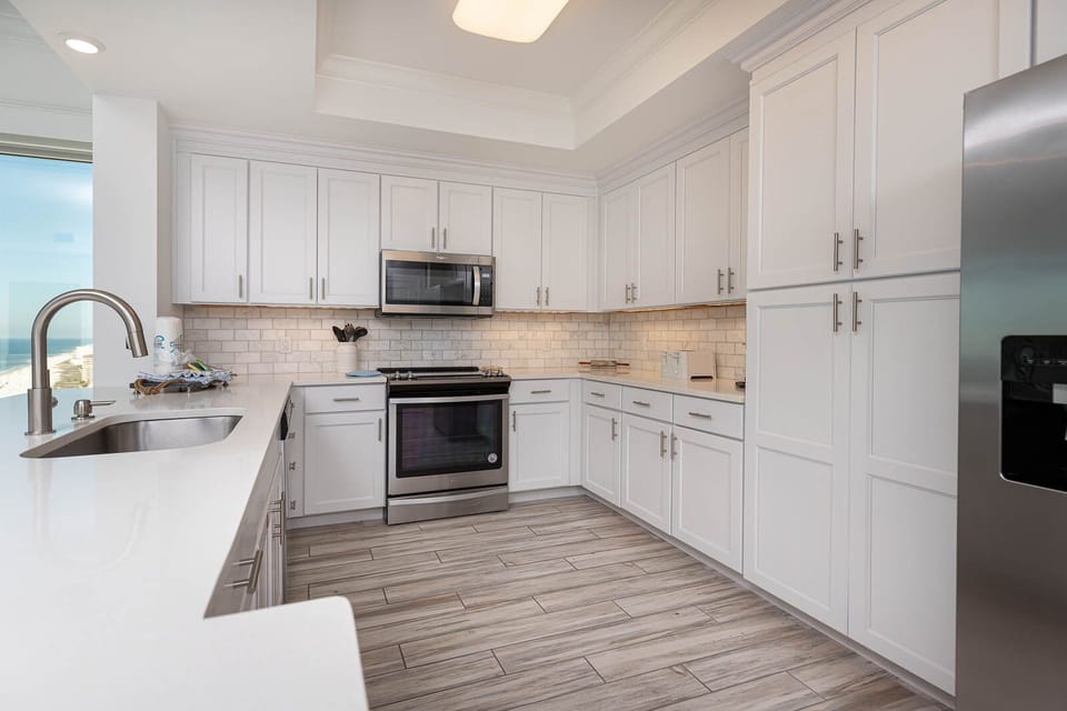 Craft delightful meals in this stylish kitchen, featuring stainless appliances and elegant lighting accents