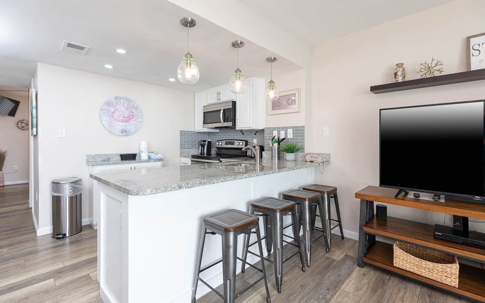 The modern kitchen features sleek granite countertops, stainless appliances, and stylish backsplash for comfortable cooking