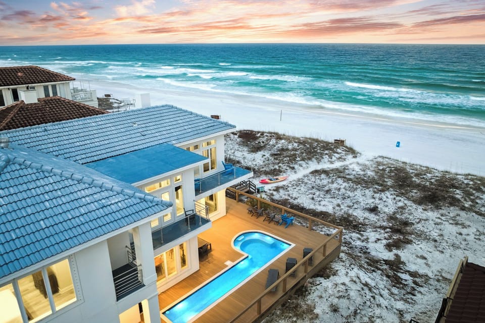 Stunning beachfront property overlooking pristine white sand and turquoise waters, featuring private pool and direct beach access.