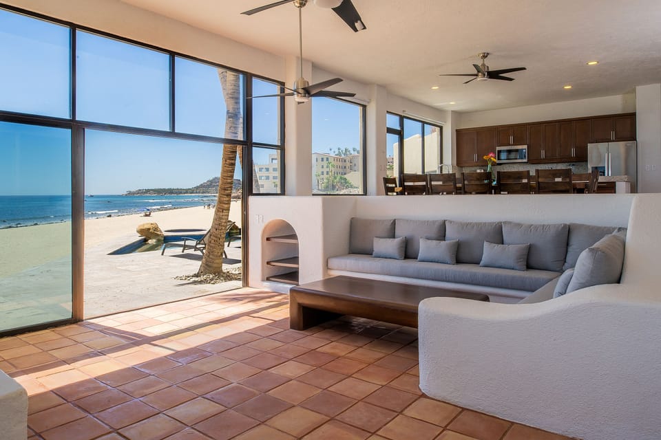 Spacious living area with beachfront views and patio access