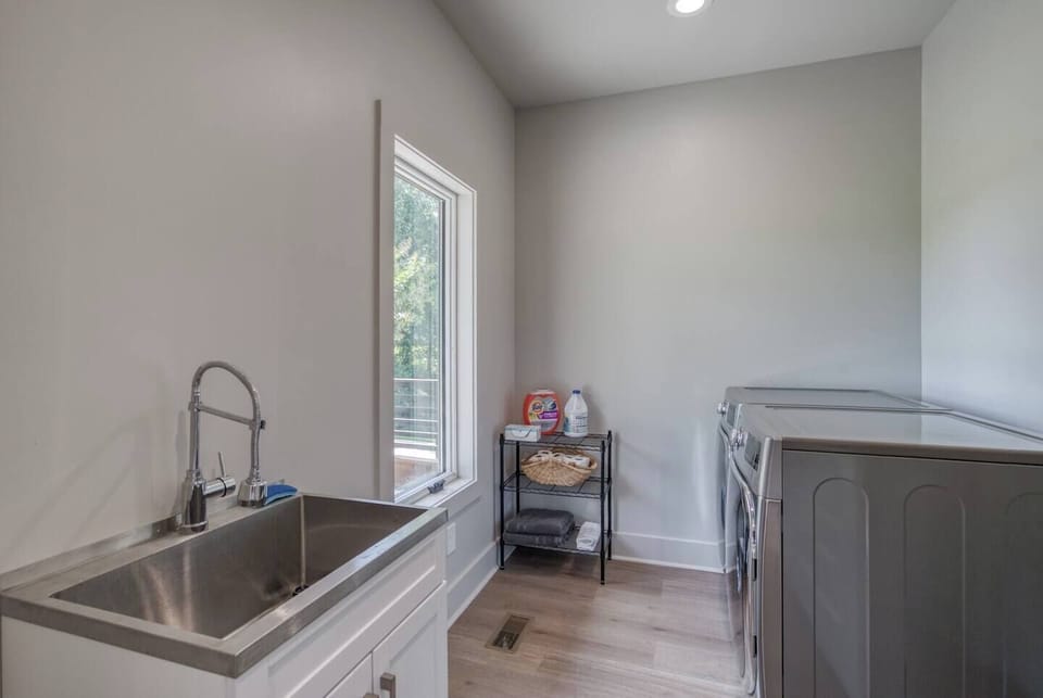 The main-level laundry room features a washer and dryer, with detergent and dryer sheets provided. You’ll also find an extra sink, vacuum, broom and dustpan, and mop for added convenience.