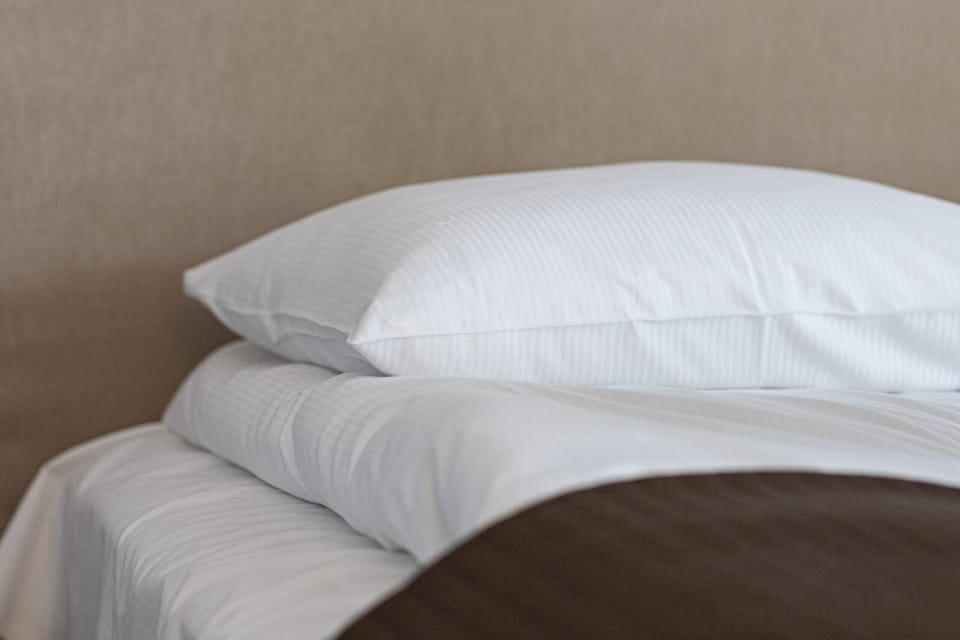 A close-up of soft, white bedding, showcasing comfort and quality.
