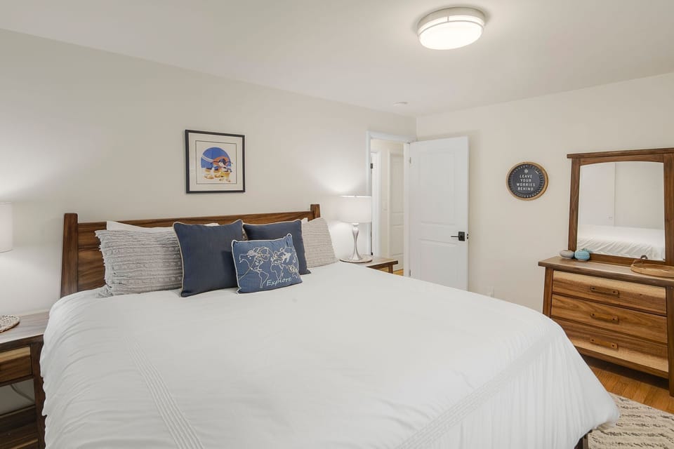 King bed with blackout shades and quality linens — set up for a proper night's sleep