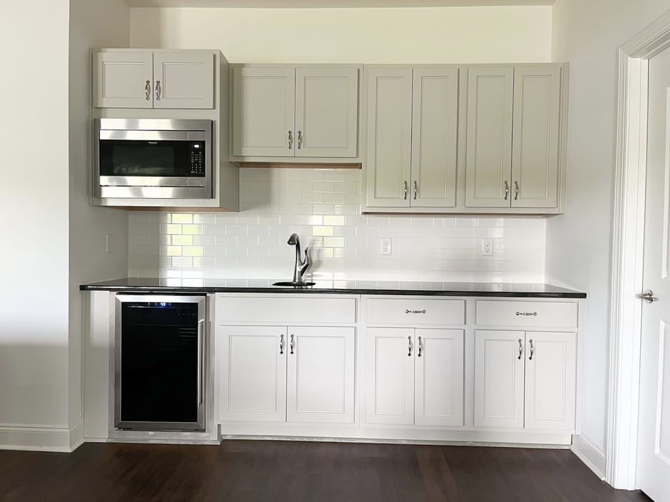 Downstairs kitchenette with microwave, refrigerator, sink, and coffee maker