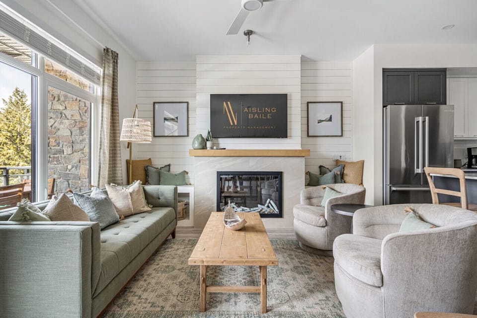 Main floor living room with a fireplace, cozy seating options, a Smart TV and walkout access to the balcony.